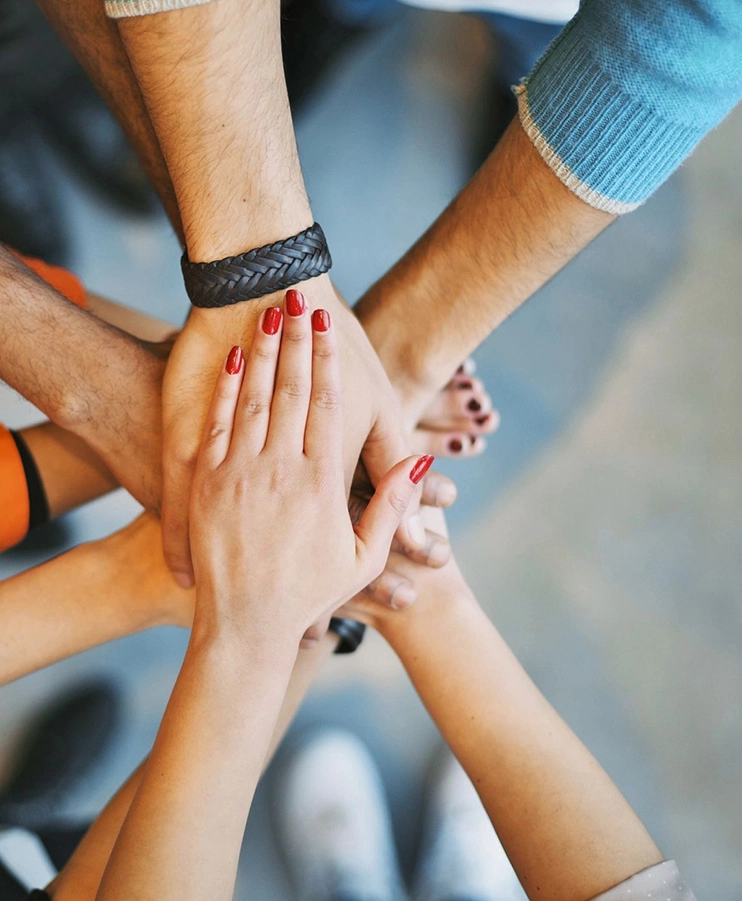 A group of people with their hands together.