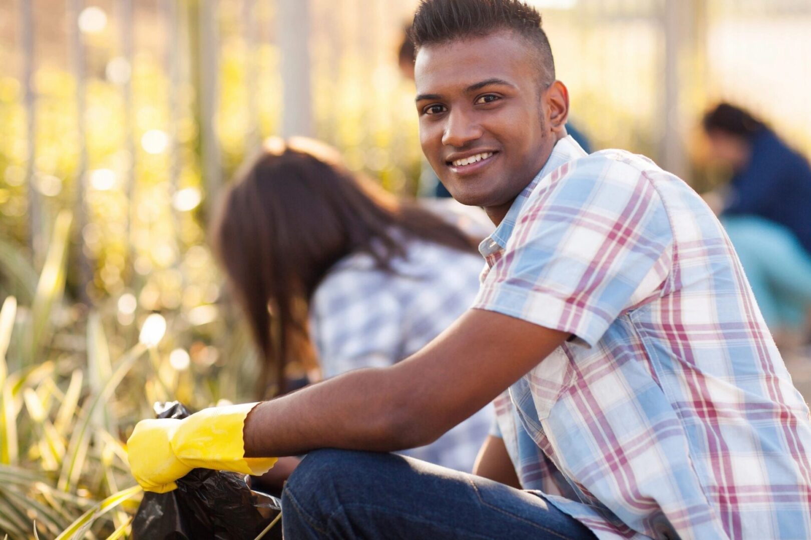 A man sitting on the ground with gloves on.