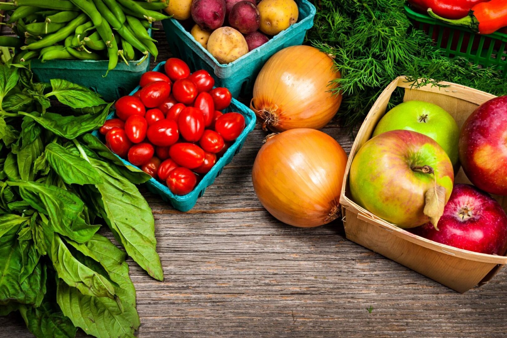 A wooden table topped with lots of fruits and vegetables.