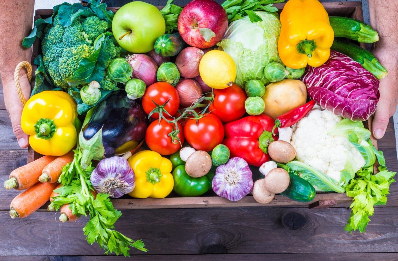 A wooden table topped with lots of different fruits and vegetables.