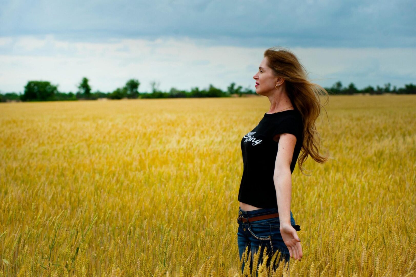 A woman standing in the middle of an open field.